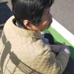 天気がいい日に、バス停でバスを待つ母