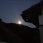 夕方、山際から出る月の画像