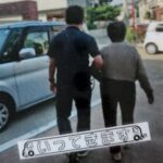 母と母を誘導して送迎の車へ向かう施設職員の画像