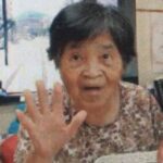 目と口と右手を開いて、おどけた表情をする母の画像
