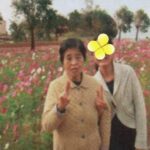 たくさんのコスモスと木々をバックに母とわたしの二人で撮った画像。