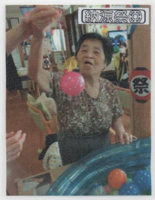 ビニールプールからヨーヨーを吊り上げる母の画像