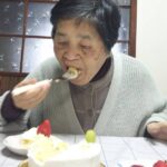 苺のショートケーキのホールケーキを幸せそうに食べている母の画像