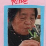 恵方巻を両手に持って、中の具の細いきゅうりだけを口にくわえている母の画像