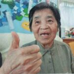 親指を立てて、笑顔の母の画像