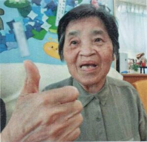 親指を立てて、笑顔の母の画像