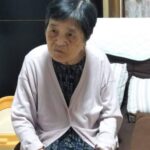 疲れたような顔でソファに座っている母の画像