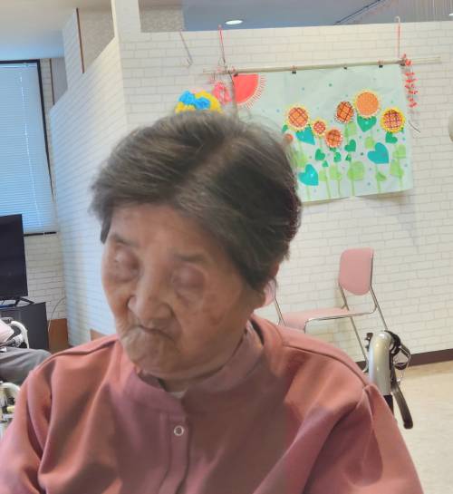 車椅子に座ったまま、ウトウトする母の画像
