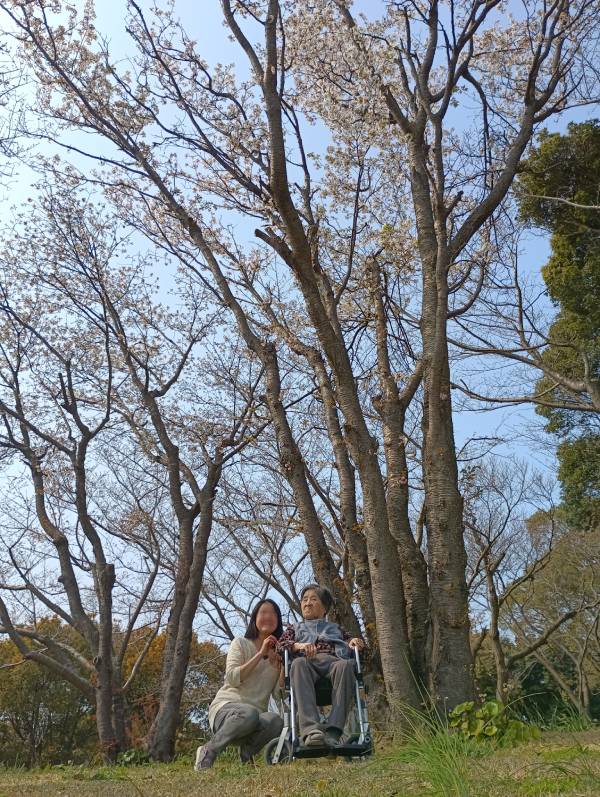 2026年の花見で唯一咲いていた桜の木の下で母と二人で撮ってもらった画像